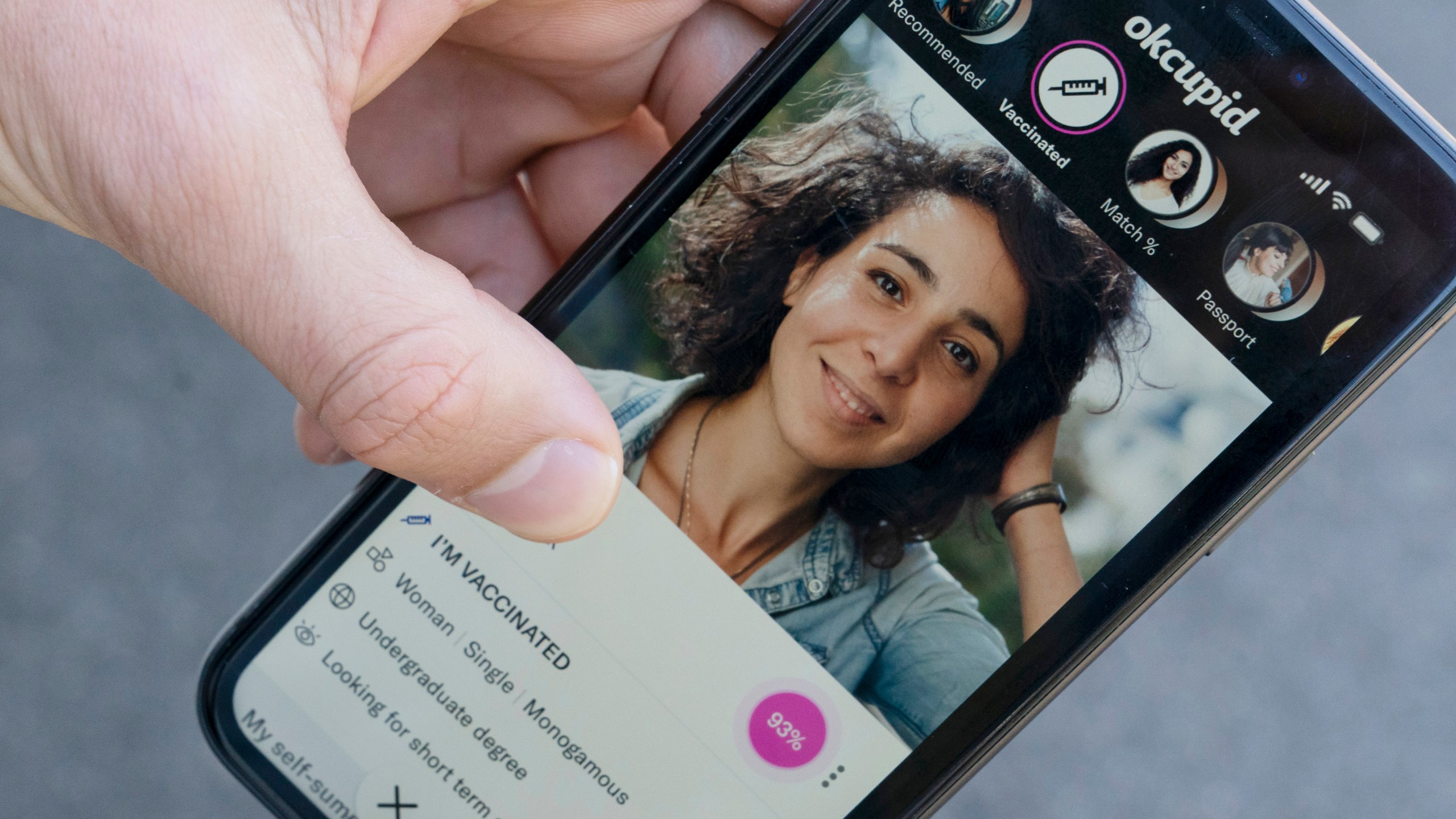 A sample page on the OkCupid app is held for a photograph showing the "I'm vaccinated," checkmark, Friday, May 21, 2021, in Washington. (AP Photo/Alex Brandon)