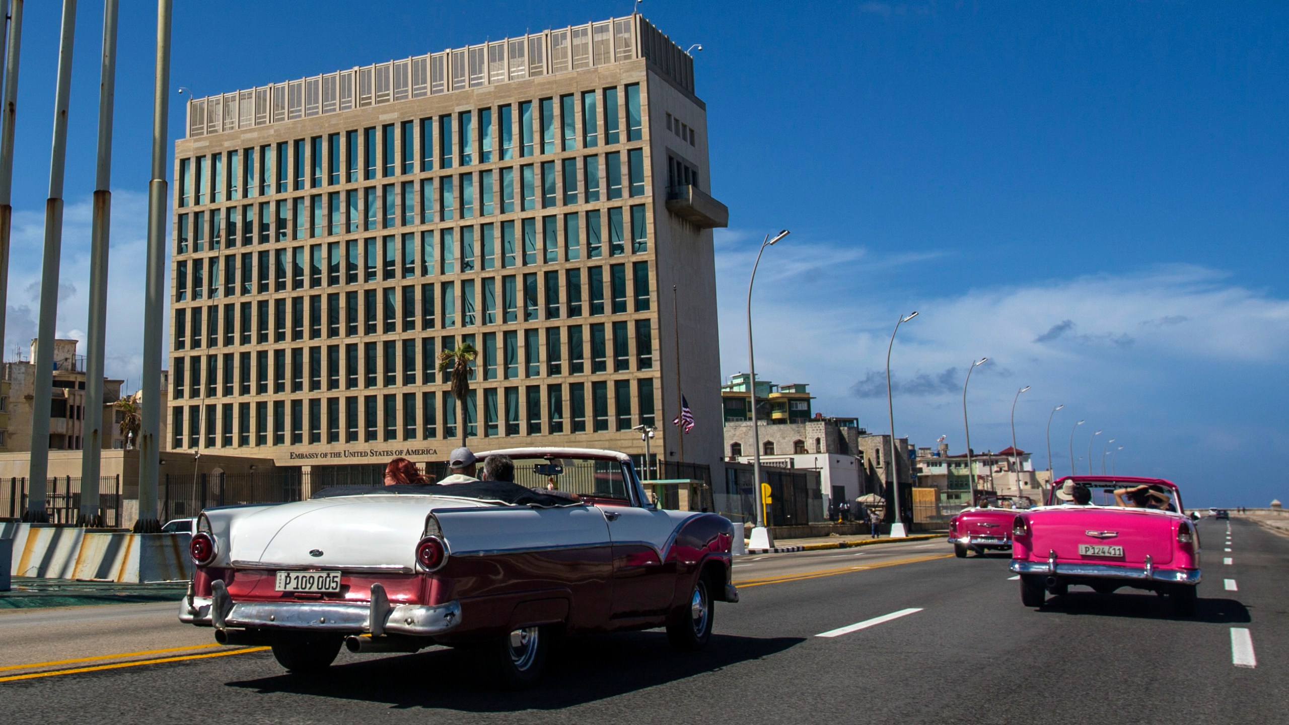 In this Oct. 3, 2017, file photo, tourists ride classic convertible cars on the Malecon beside the United States Embassy in Havana, Cuba. (AP Photo/Desmond Boylan, File)