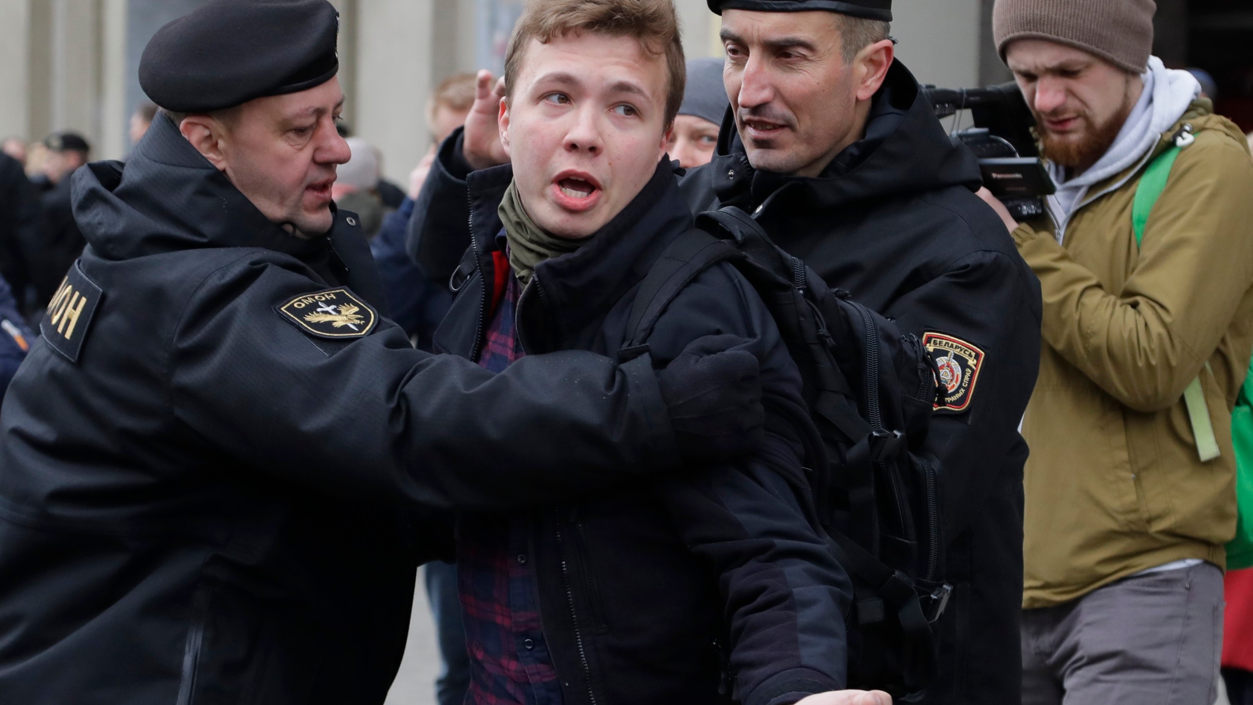 In this Sunday, March 26, 2017 file photo, Belarus police detain journalist Raman Pratasevich, center, in Minsk, Belarus. Raman Pratasevich, a founder of a messaging app channel that has been a key information conduit for opponents of Belarus’ authoritarian president, has been arrested after an airliner in which he was riding was diverted to Belarus because of a bomb threat. The presidential press service said President Alexander Lukashenko personally ordered that a MiG-29 fighter jet accompany the Ryanair plane — traveling from Athens, Greece, to Vilnius, Lithuania — to the Minsk airport. ﻿﻿(AP Photo/Sergei Grits, File)