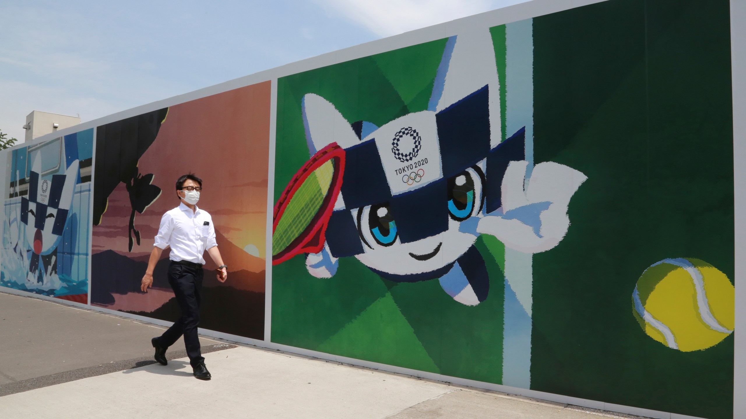 A man walks by posters promoting the Olympic Games planned to start in the summer of 2021, in Tokyo, Monday, May 24, 2021. (AP Photo/Koji Sasahara)