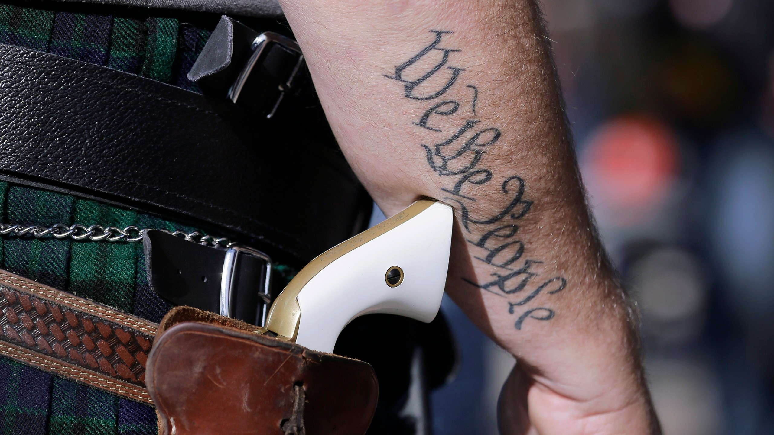 In this Jan. 26, 2015 file photo, a supporter of open carry gun laws, wears a pistol as he prepares for a rally in support of open carry gun laws at the Capitol, in Austin, Texas. Texas lawmakers have given final approval to allowing people carry handguns without a license, and the background check and training that go with it. The Republican-dominated Legislature approved the measure Monday, May 24, 2021 sending it to Gov. Abbott. (AP Photo/Eric Gay, File)