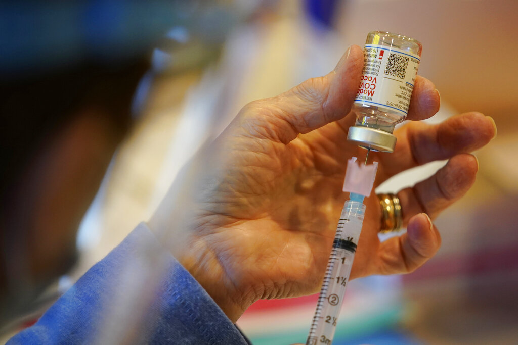 In this Dec. 29, 2020, file photo, Pat Moore, with the Chester County, Pa., Health Department, fills a syringe with Moderna COVID-19 vaccine. (AP Photo/Matt Slocum, File)