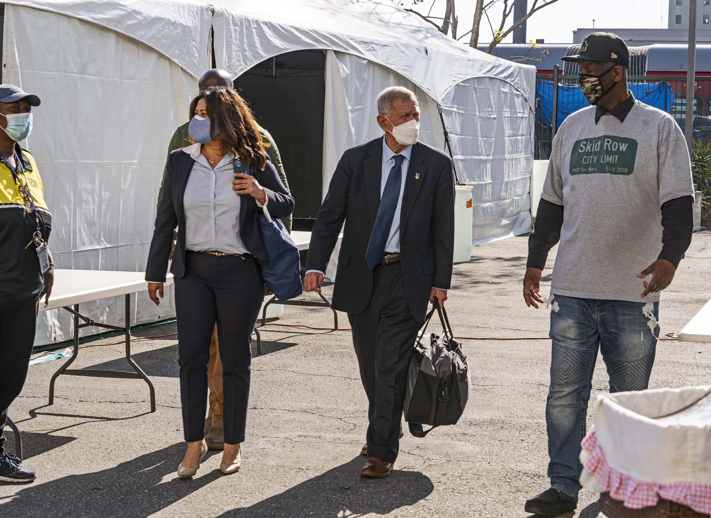 In this Feb. 4, 2021, file photo, Jeff Page, a homelessness activist, walks with U.S. District Court Judge David O. Carter, middle, and Michele Martinez, special master on the issues of homelessness, after a court hearing at Downtown Women's Center in Los Angeles. (AP Photo/Damian Dovarganes, File)