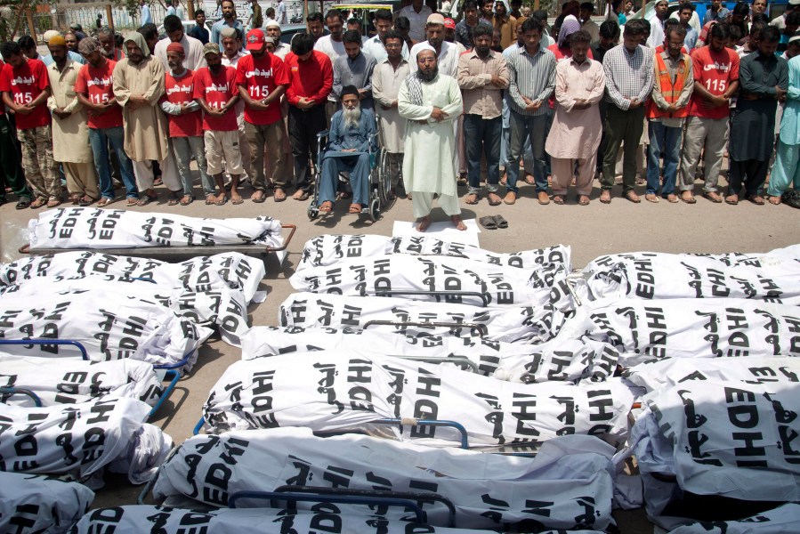 In this June 26, 2015 file photo, mourners attend a funeral for unclaimed people who died of extreme weather in Karachi, Pakistan after a devastating heat wave that struck southern Pakistan the previous weekend, with over 800 confirmed deaths according to a senior health official. A study published in Nature Climate Change on May 31, 2021, has calculated that more than one-third of global heat deaths can directly be attributed to human-caused climate change. (Shakil Adil/Associated Press)