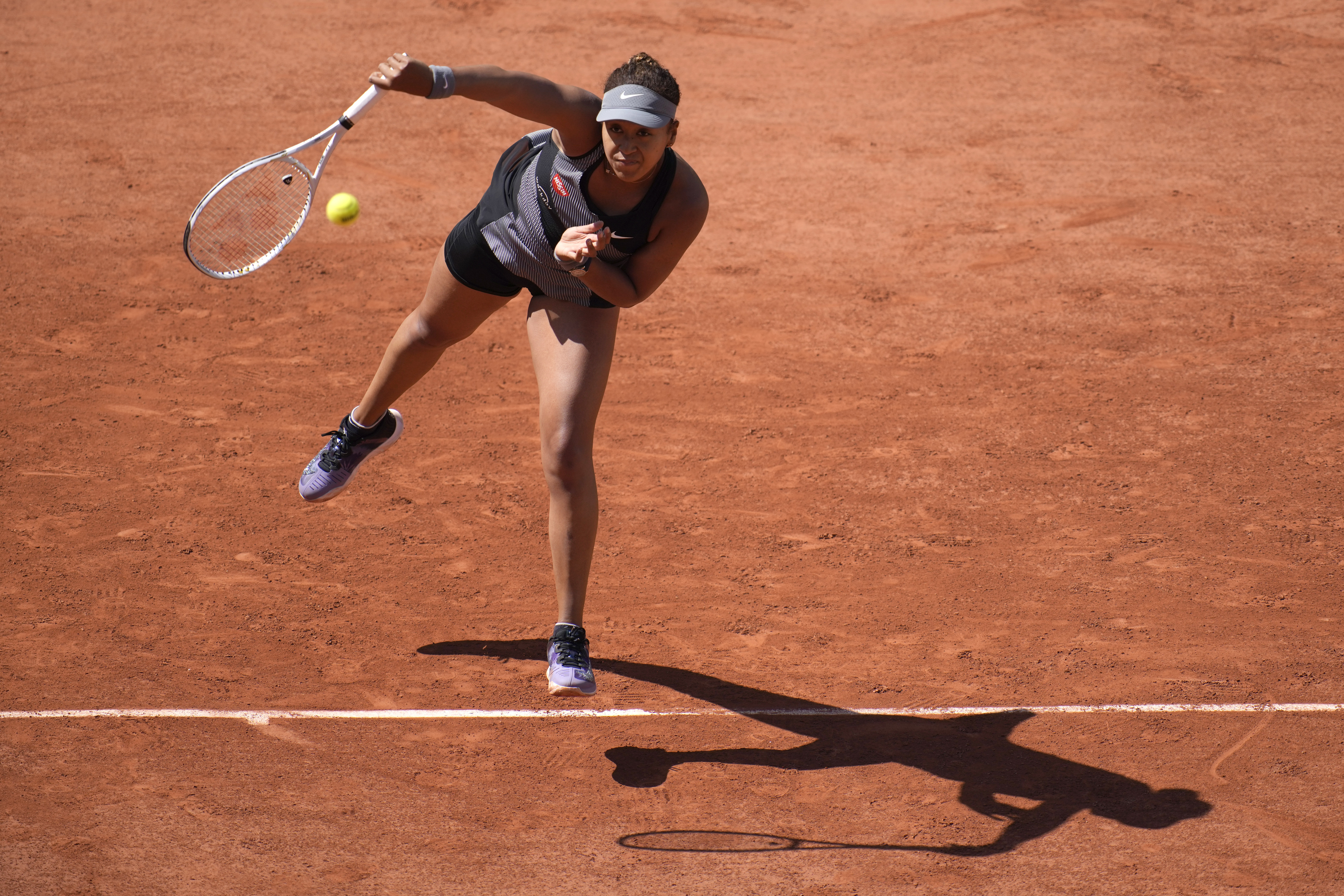 Japan's Naomi Osaka serves the ball to Romania's Patricia Maria Tig during their first round match of the French Open tennis tournament at the Roland Garros stadium Sunday, May 30, 2021 in Paris. (AP Photo/Christophe Ena)