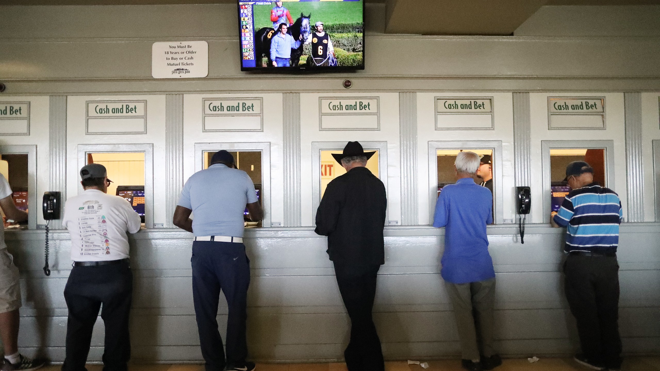 Gamblers stand at betting windows on the final day of the winter/spring horse racing season at Santa Anita Park on June 23, 2019 in Arcadia, California. (Mario Tama/Getty Images)