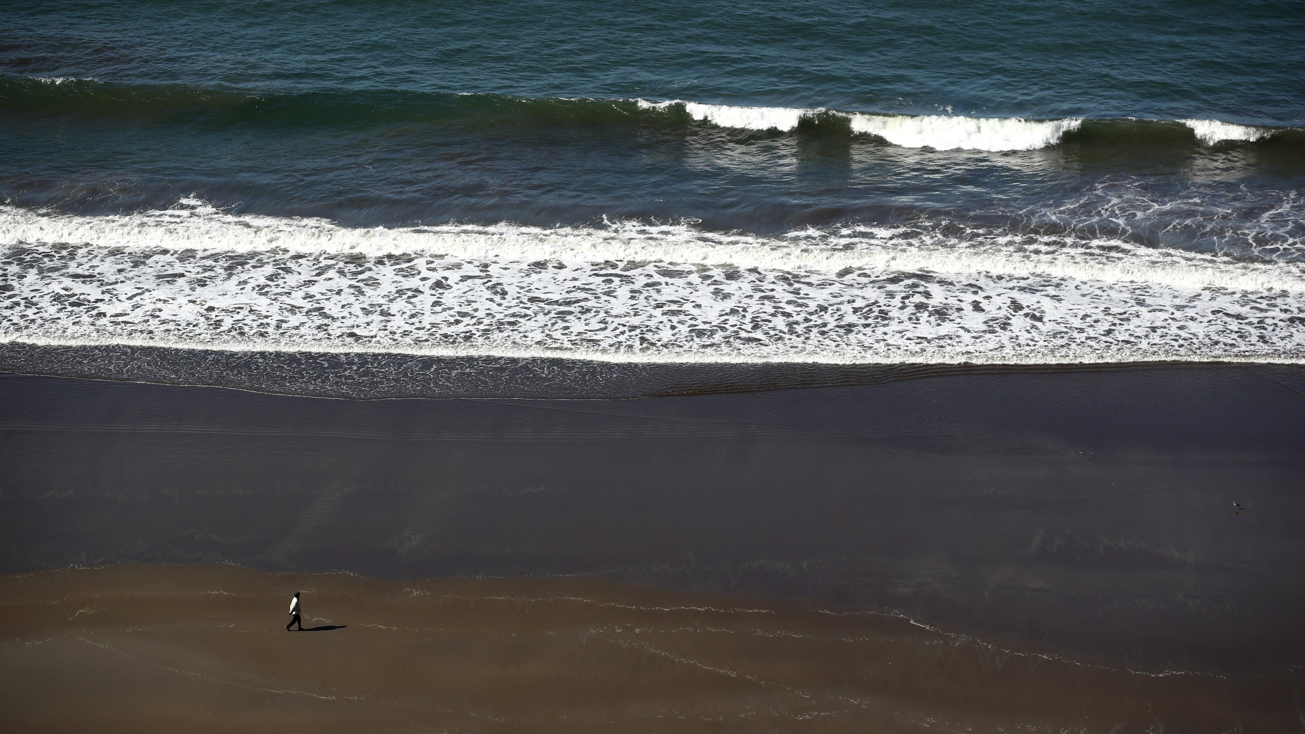 A view of a women walking on Stinson Beach, which is closed because of the Coronavirus (COVID-19), on April 01, 2020 in Stinson Beach, California. (Ezra Shaw/Getty Images)