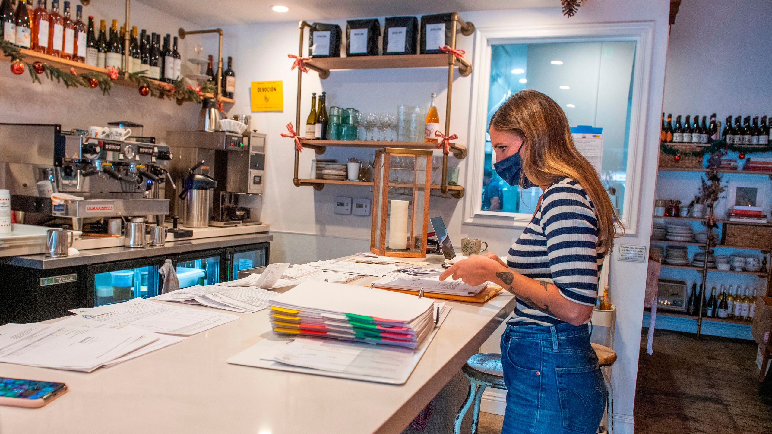 Sarah Bessade, owner of "La Loupiotte Kitchen", a restaurant in Los Angeles, works on her accounts in the restaurant's kitchen on Dec. 8, 2020. (VALERIE MACON/AFP via Getty Images)