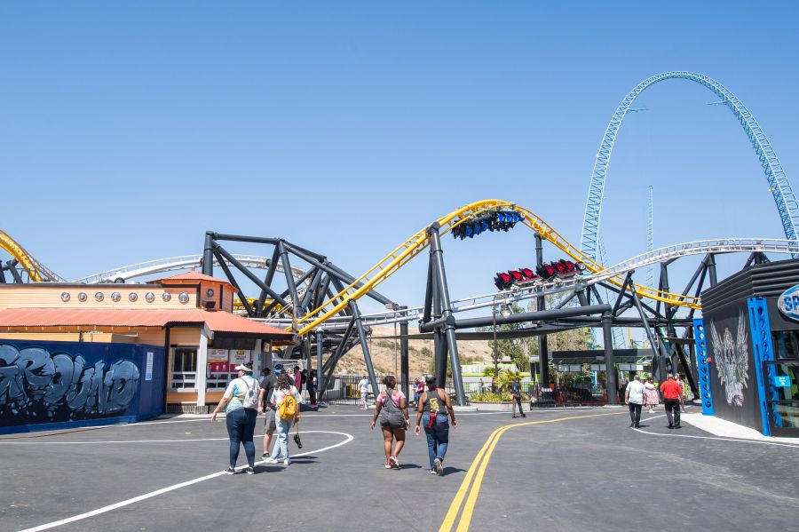 Visitors walk past the West Coast Racers roller coaster at Six Flags Magic Mountain on April 1, 2021. (VALERIE MACON/AFP via Getty Images)