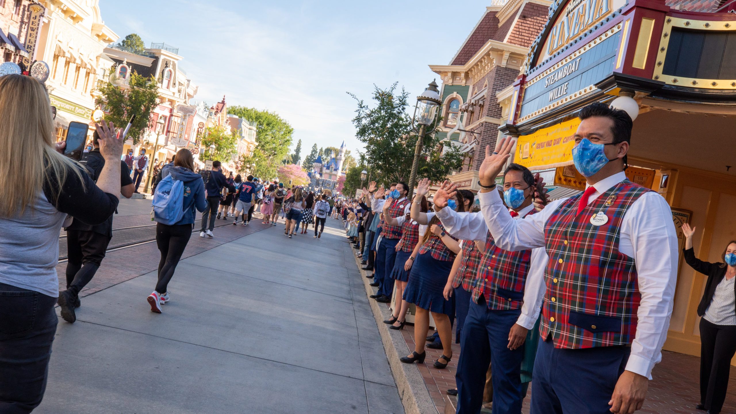 In this handout photo provided by Disneyland Resort, guests are waved to by workers as they take in the sights and sounds of Main Street U.S.A. at the Disneyland Resort on April 30, 2021 in Anaheim, Calif. Guests are being welcomed back as Disneyland Park, Disney California Adventure Park and Disney's Grand Californian Hotel & Spa are reopening. (Christian Thompson/Disneyland Resort via Getty Images)