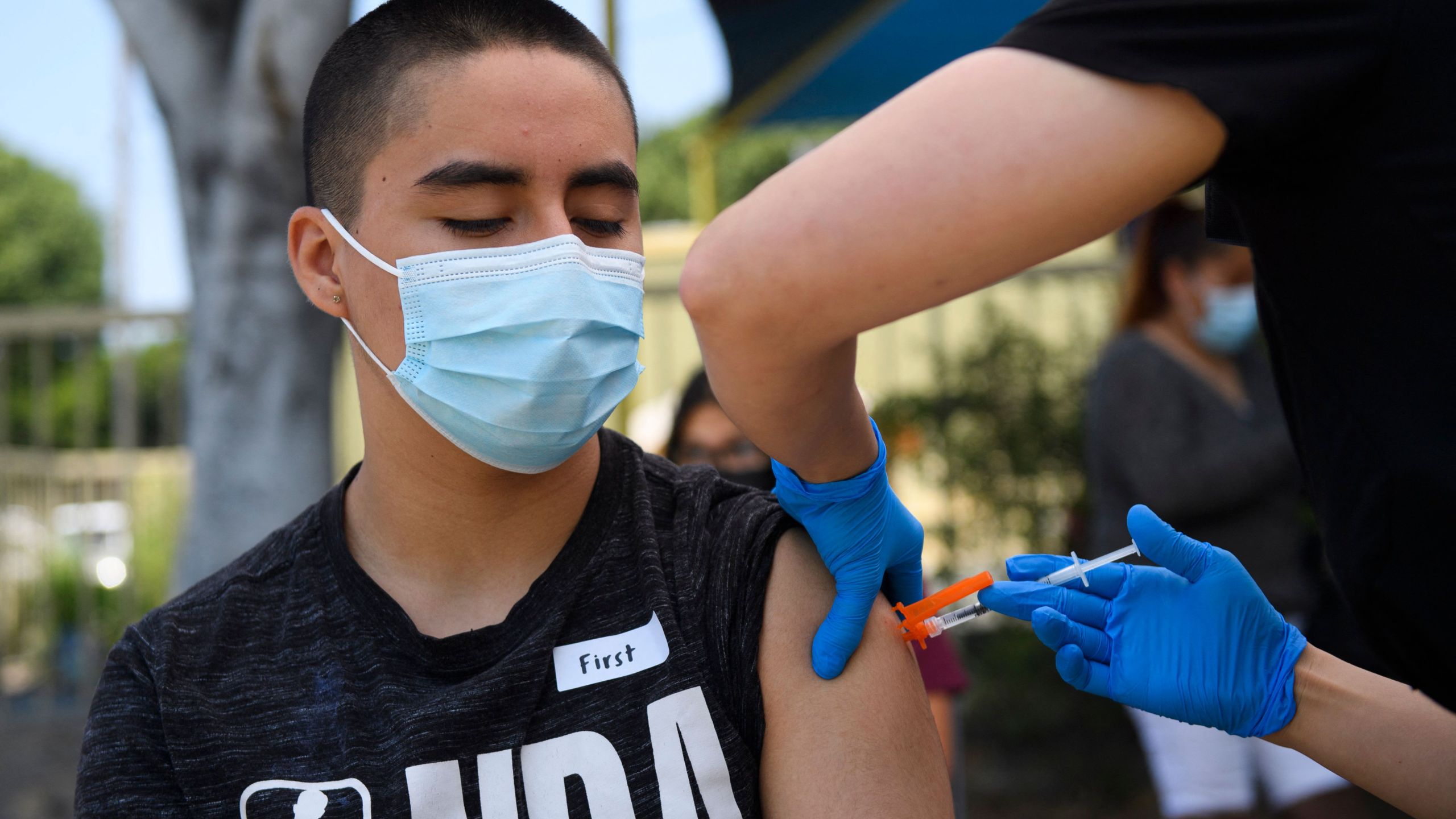 Hector Garnica, 13, receives a first dose of the Pfizer Covid-19 vaccine at a mobile vaccination clinic at the Weingart East Los Angeles YMCA on May 14, 2021 in Los Angeles, California. (PATRICK T. FALLON/AFP via Getty Images)