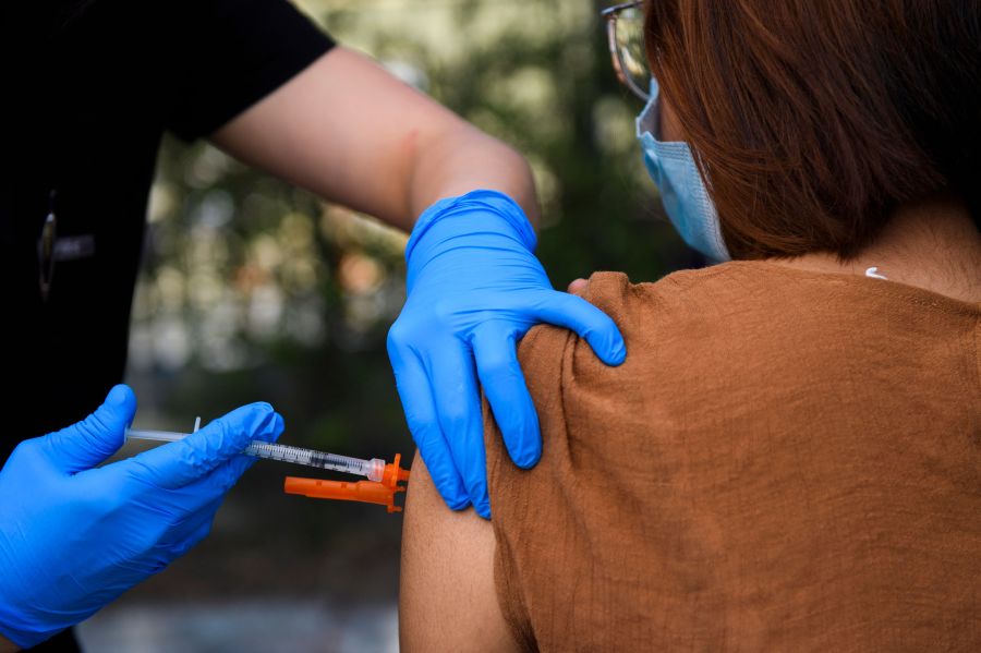 A 15-year-old receives a first dose of the Pfizer COVID-19 vaccine at a mobile vaccination clinic at the Weingart East Los Angeles YMCA on May 14, 2021. (Patrick T. Fallon / AFP / Getty Images)