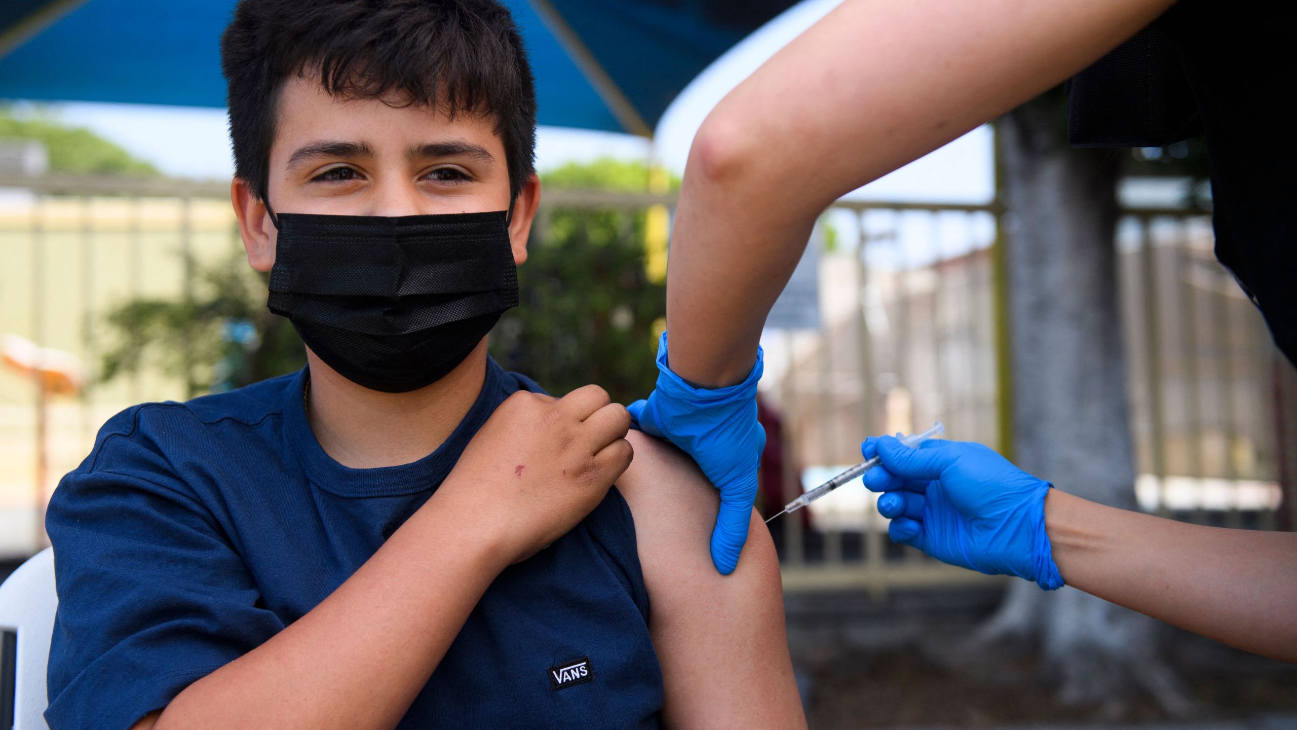 Simon Huizar, 13, receives a first dose of the Pfizer COVID-19 vaccine at a mobile vaccination clinic at the Weingart East Los Angeles YMCA on May 14, 2021, in Los Angeles.