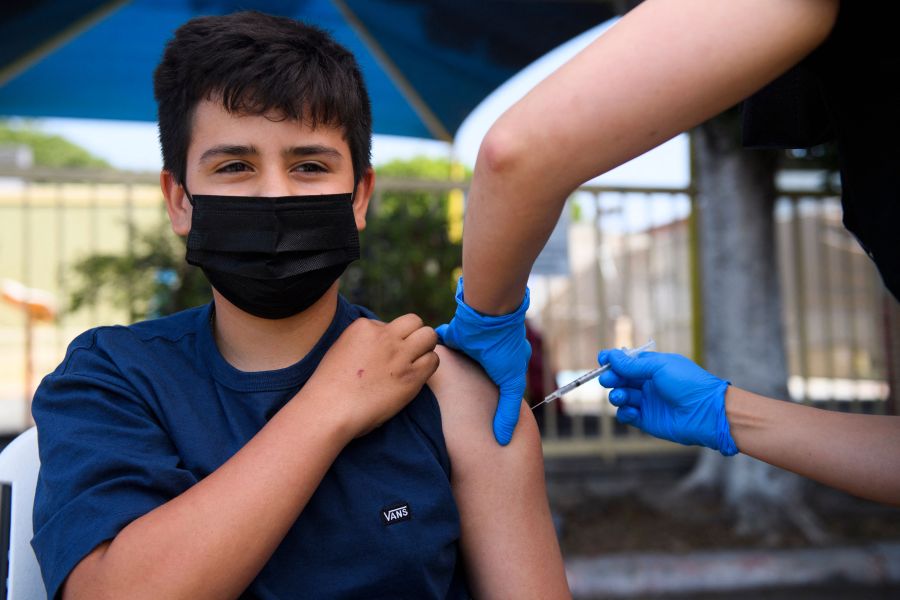 Simon Huizar, 13, receives a first dose of the Pfizer COVID-19 vaccine at a mobile vaccination clinic at the Weingart East Los Angeles YMCA on May 14, 2021, in Los Angeles.