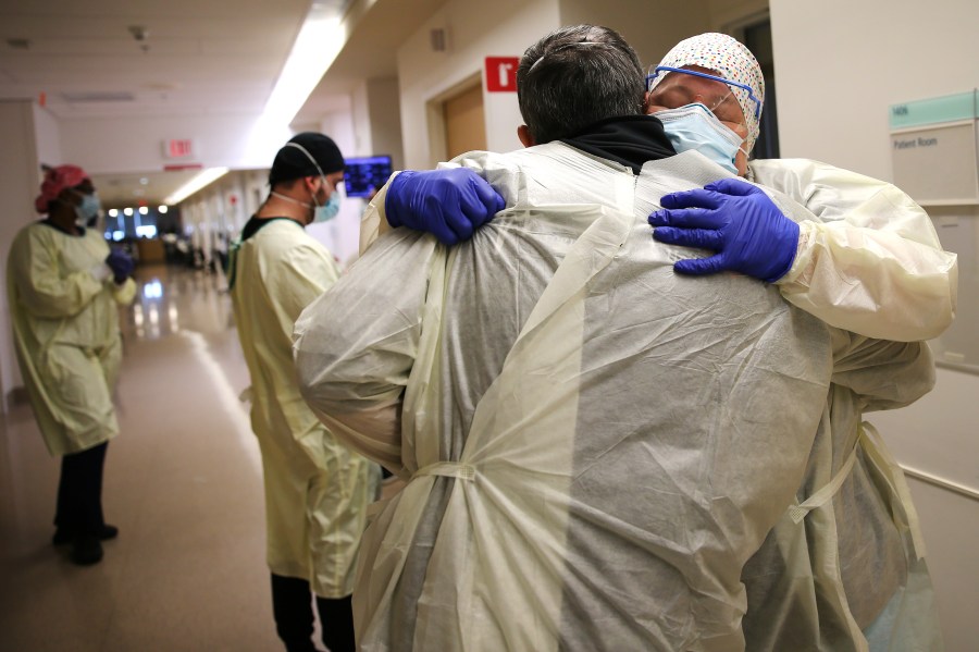 Chaplain Kevin Deegan hugs registered nurse Connie Carrillo at Providence Holy Cross Medical Center in the Mission Hills neighborhood in Los Angeles on Feb. 17, 2021. (Mario Tama / Getty Images)