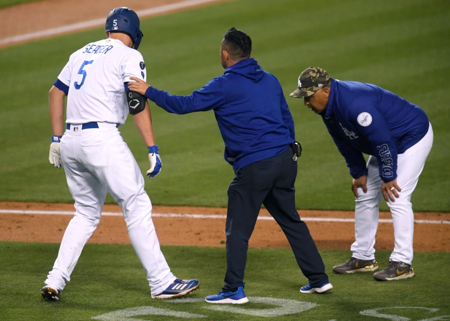 Corey Seager #5 of the Los Angeles Dodgers is helped by Dodgers medical staff after he was hit by a pitch, as Dave Roberts #30 looks on, during the fifth inning at Dodger Stadium on May 15, 2021 in Los Angeles. (Harry How/Getty Images)