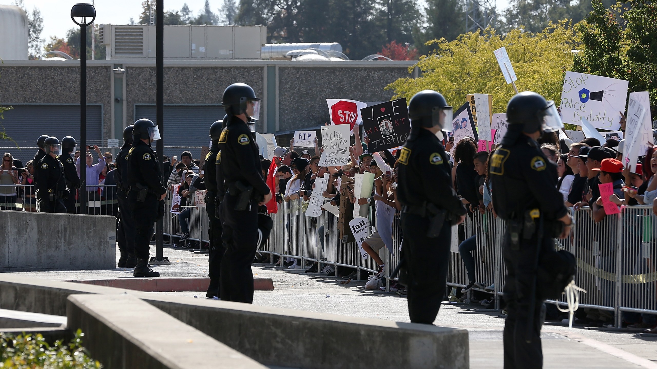 Sonoma County sheriff's deputies line up in front of protestors during a rally in front of the Sonoma County sheriff's office for 13 year-old Andy Lopez, who was shot by a Sonoma County sheriff's deputy the week prior, on Oct. 29, 2013, in Santa Rosa. (Justin Sullivan/Getty Images)