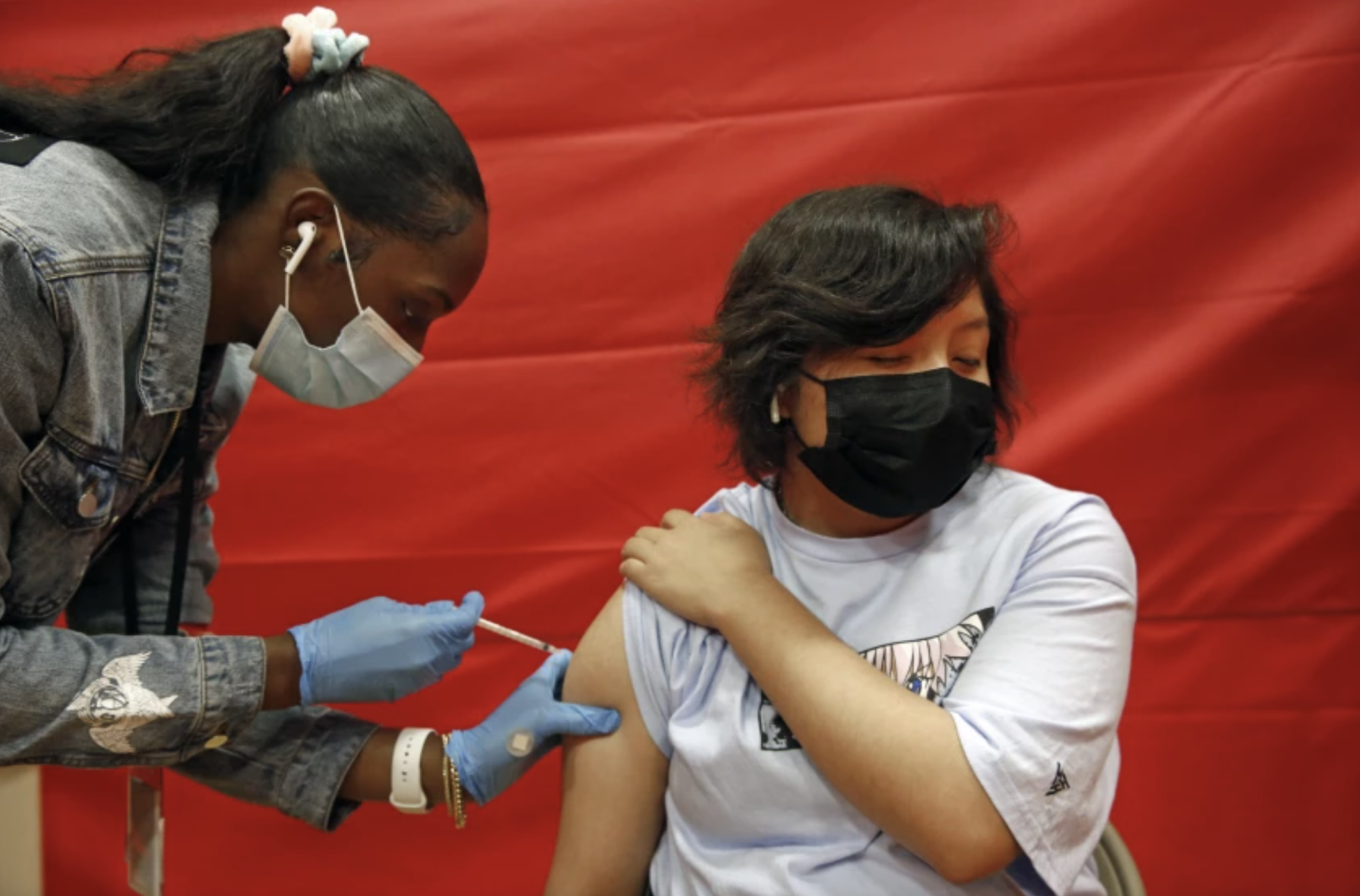 Alex Olvera, 15, is vaccinated against COVID-19 in a gym at Manual Arts High School, south of downtown on May 17, 2021. (Dania Maxwell / Los Angeles Times)