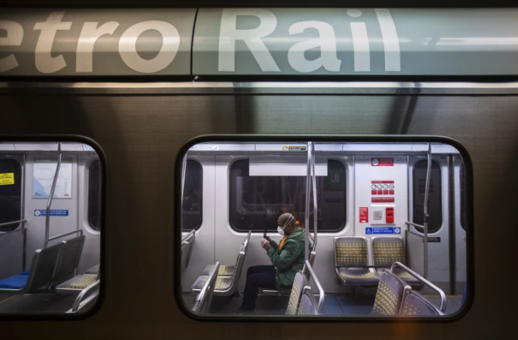 A man sits in a nearly empty train car on the Metro Blue Line at the 7th and Metro station in Los Angeles last year. (Brian van der Brug / Los Angeles Times)