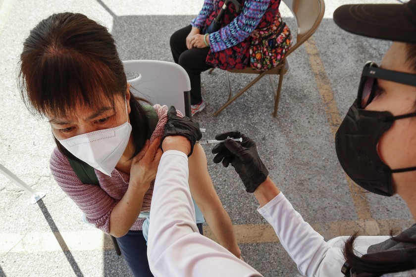 A woman receives a COVID-19 vaccination at a mobile clinic in Chinatown.(Al Seib / Los Angeles Times)