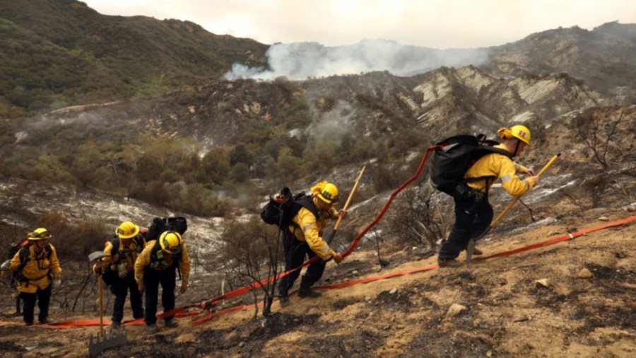 Firefighters work between Pacific Palisades and Topanga Canyon as air drops continued Sunday.(Carolyn Cole / Los Angeles Times)