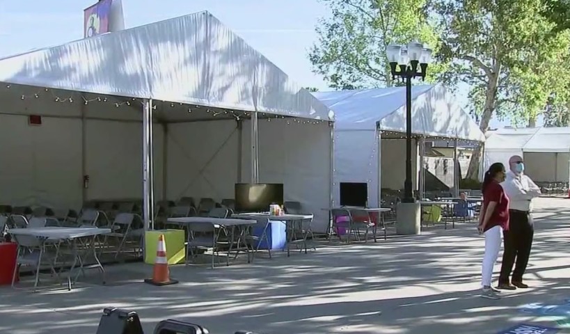 People at the Pomona Fairplex prepare for the arrival of 250 migrant children May 1, 2021, as the facility is expected to temporarily house the minors. (KTLA)