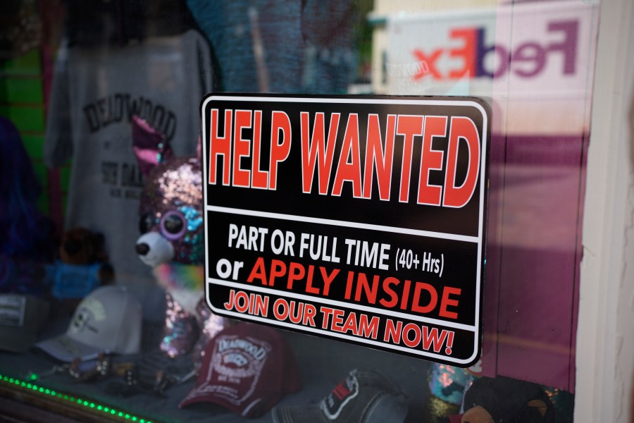 In this May 26, 2021 photo, a sign for workers hangs in the window of a shop along Main Street in Deadwood, S.D. U.S. employers added 559,000 jobs in May, an improvement from April’s sluggish gain but still evidence that many companies are struggling to find enough workers as the economy rapidly recovers from the pandemic recession. (AP Photo/David Zalubowski)