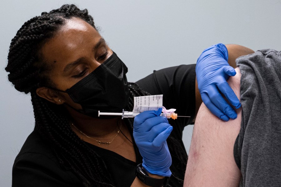 In this Wednesday, March 31, 2021 file photo, Cole Smith receives a Moderna variant vaccine shot from clinical research nurse Tigisty Girmay at Emory University's Hope Clinic in Decatur, Ga. As of June 2021, scientists have found clues that the world’s leading COVID-19 vaccines offer lasting protection that could diminish the need for frequent booster shots, but they caution that more research is needed and that virus mutations are still a wild card. (AP Photo/Ben Gray, File)