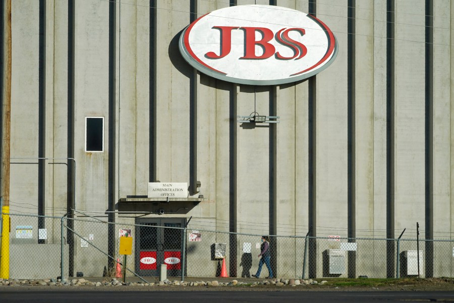 In this Oct. 12, 2020 file photo, a worker heads into the JBS meatpacking plant in Greeley, Colo. A weekend ransomware attack on the world’s largest meat company is disrupting production around the world just weeks after a similar incident shut down a U.S. oil pipeline. The White House confirms that Brazil-based meat processor JBS SA notified the U.S. government Sunday, May 30, 2021, of a ransom demand from a criminal organization likely based in Russia. (AP Photo/David Zalubowski, File)