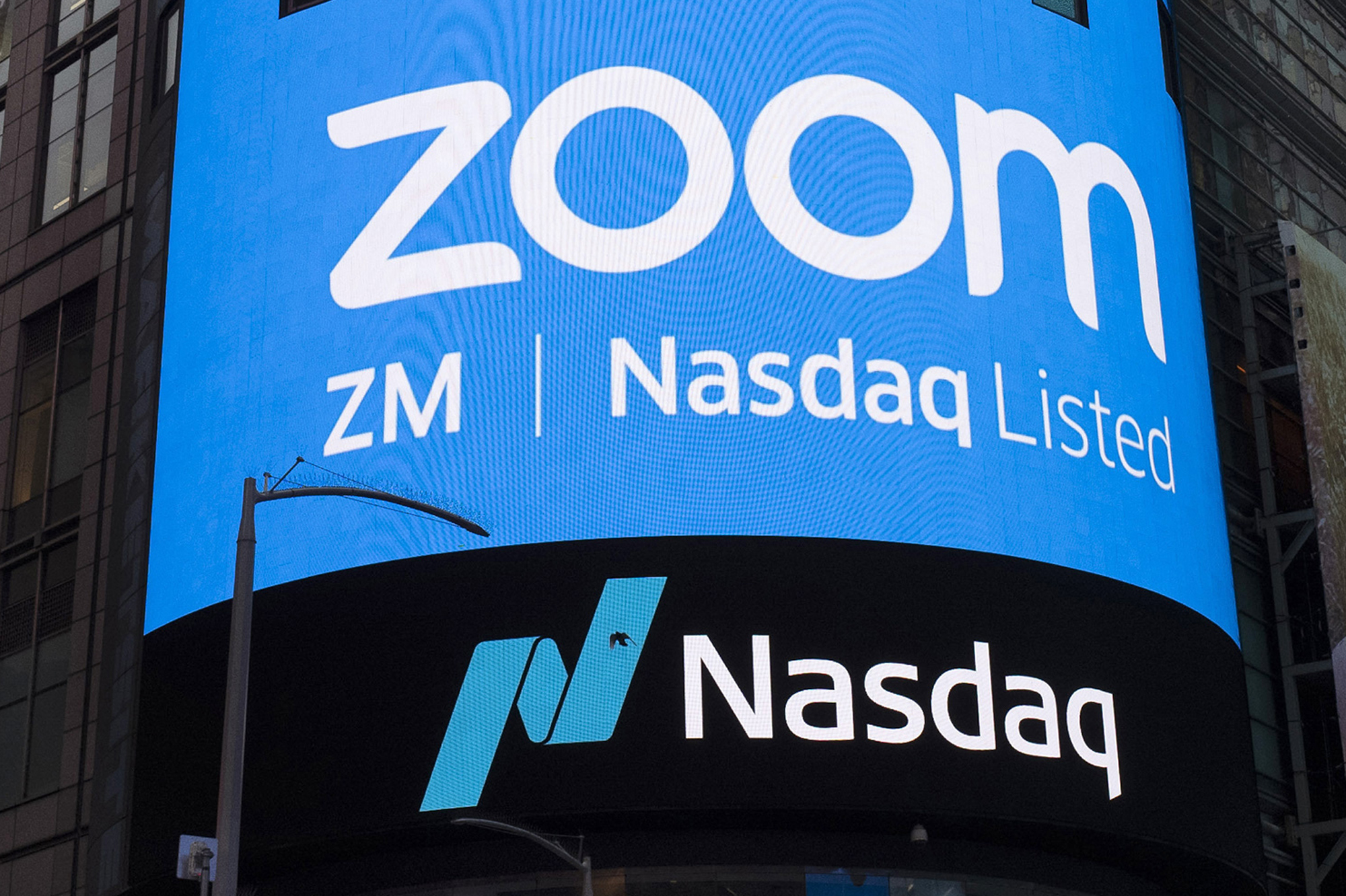 This April 18, 2019, file photo shows a sign for Zoom Video Communications ahead of their Nasdaq IPO in New York. (AP Photo/Mark Lennihan, File)