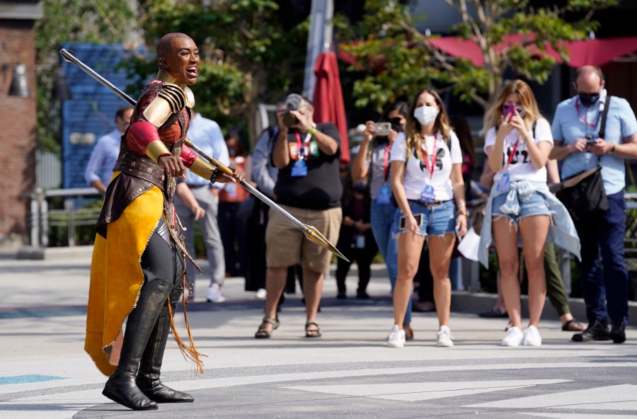 Guests look on as a character from the film "Black Panther" performs during "The Warriors of Wakanda: The Disciplines of the Dora Milaje" show at the Avengers Campus media preview at Disney's California Adventure Park on June 2, 2021, in Anaheim, Calif. (AP Photo/Chris Pizzello)