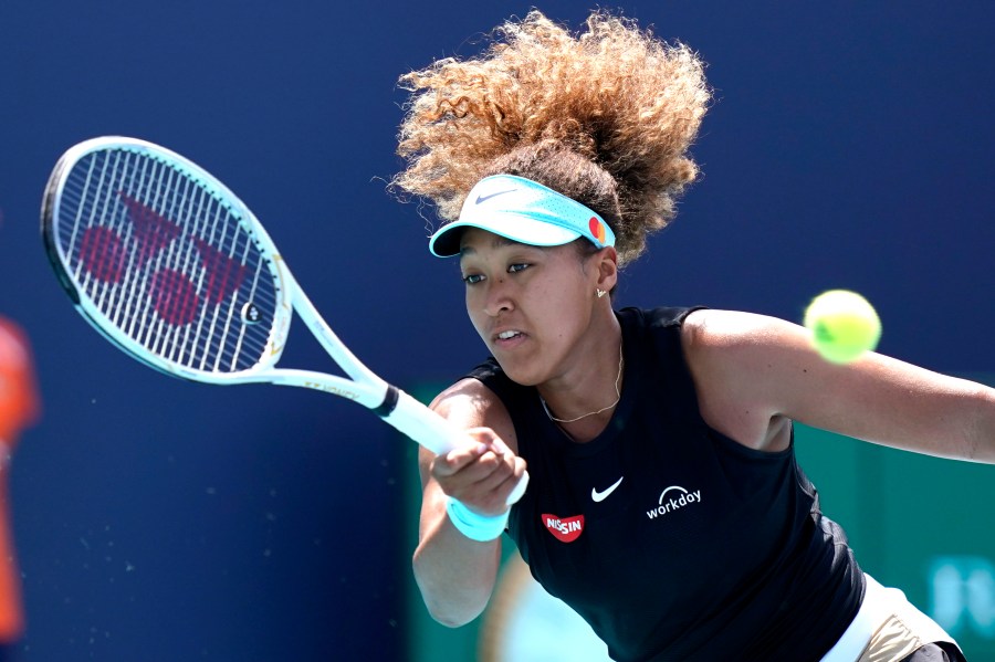 In this March 31, 2021 file photo, Naomi Osaka, of Japan, returns to Maria Sakkari, of Greece, during the quarterfinals of the Miami Open tennis tournament in Miami Gardens, Fla. Sponsors of Osaka are sticking by the her after she withdrew from the French Open, citing mental health issues relating to the press conferences required for players. Osaka, a four-time Grand Slam champion, said Monday, May 31, she was withdrawing from the French Open for mental health issues. (AP Photo/Lynne Sladky, File)