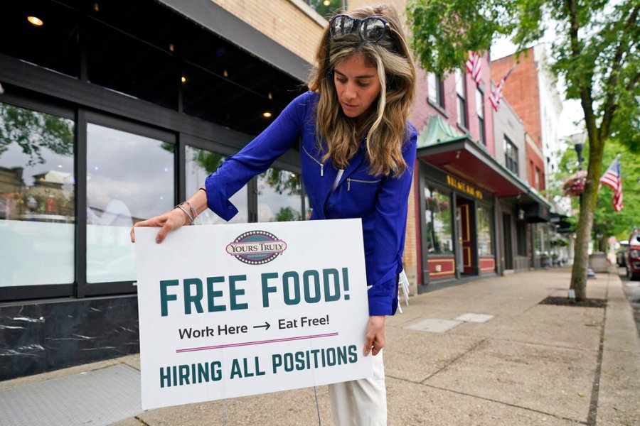 Coleen Piteo, director of marketing at Yours Truly restaurant, puts out a sign for hiring, Thursday, June 3, 2021, in Chagrin Falls, Ohio. (AP Photo/Tony Dejak)