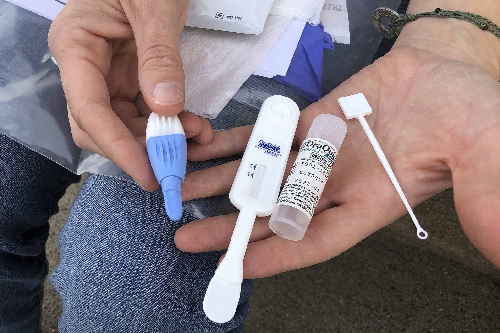 In this March 9, 2021 file photo, Solutions Oriented Addiction Response organizer Brooke Parker holds an HIV testing kit in Charleston, West Virginia. (John Raby/Associated Press)