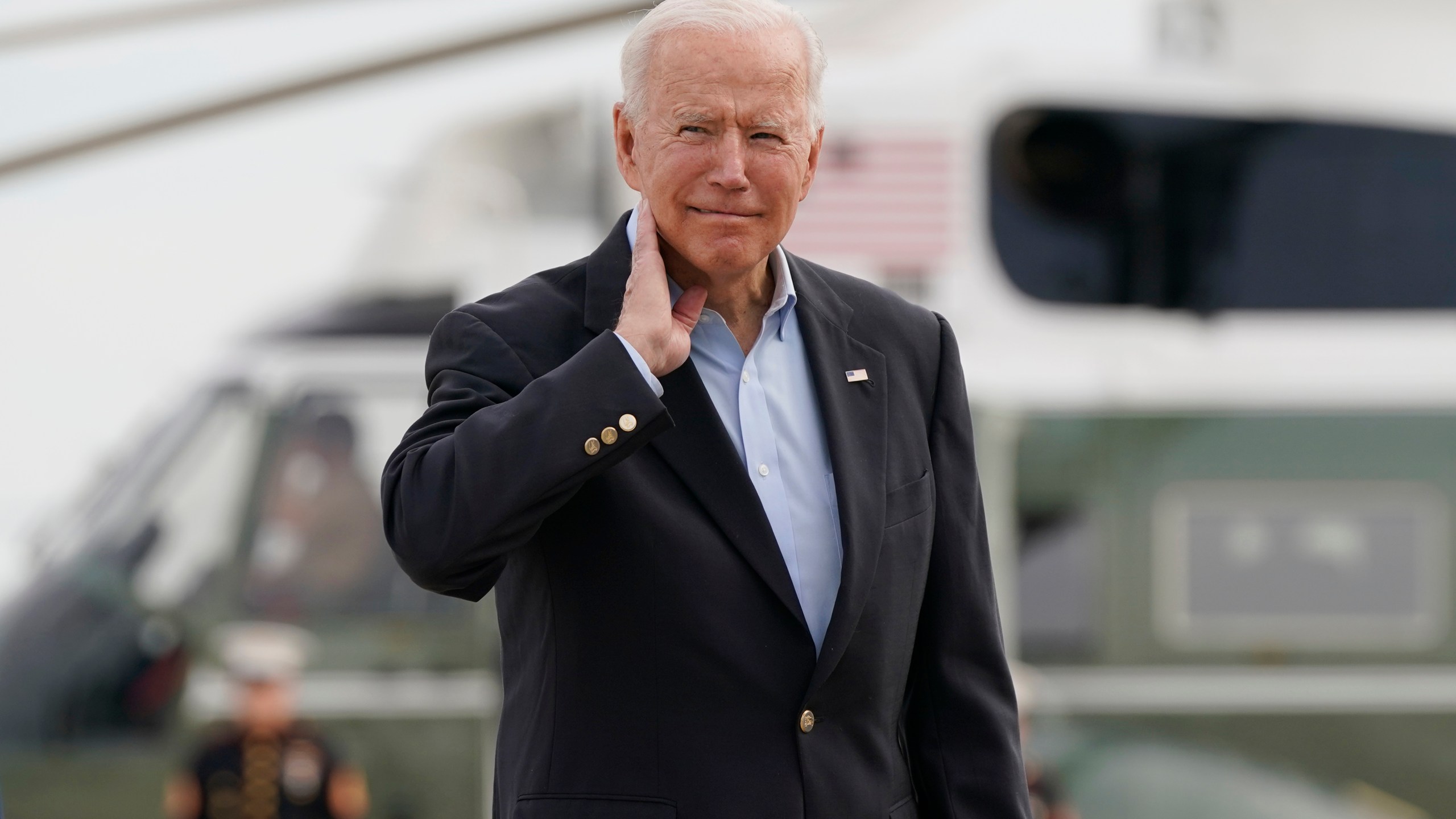 President Joe Biden pantomimes how he earlier had to brush a cicada off his neck as he and first lady Jill Biden prepare to board Air Force One, June 9, 2021, at Andrews Air Force Base, Md. (AP Photo/Patrick Semansky)