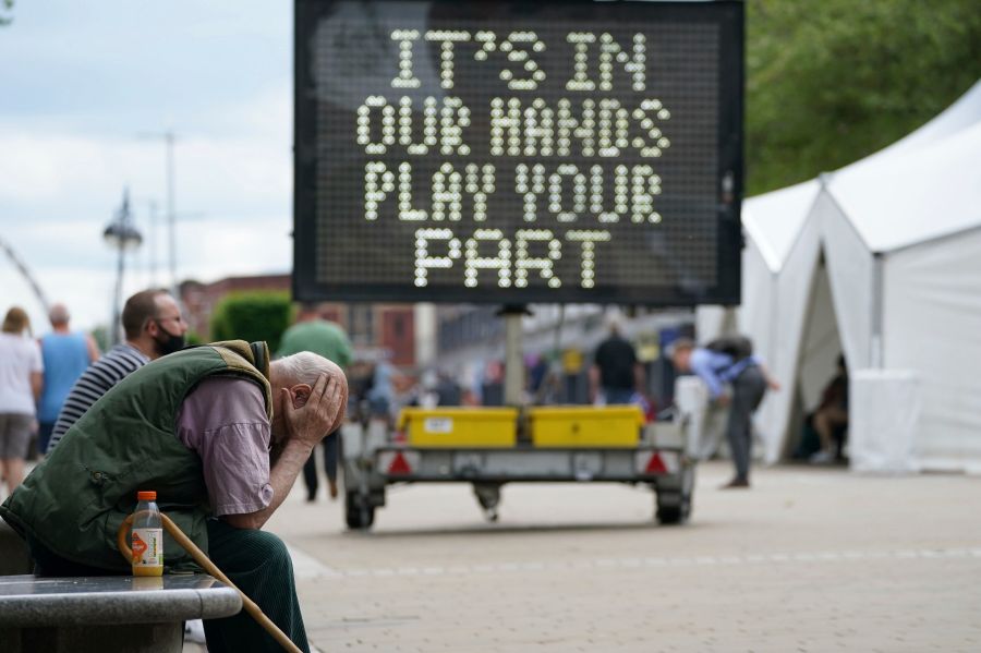 A man waits outside a mobile COVID-19 vaccination centre outside Bolton Town Hall, in Bolton, England, Wednesday, June 9, 2021, where case numbers of the Delta variant first identified in India have been relatively high. (Peter Byrne/PA via AP)