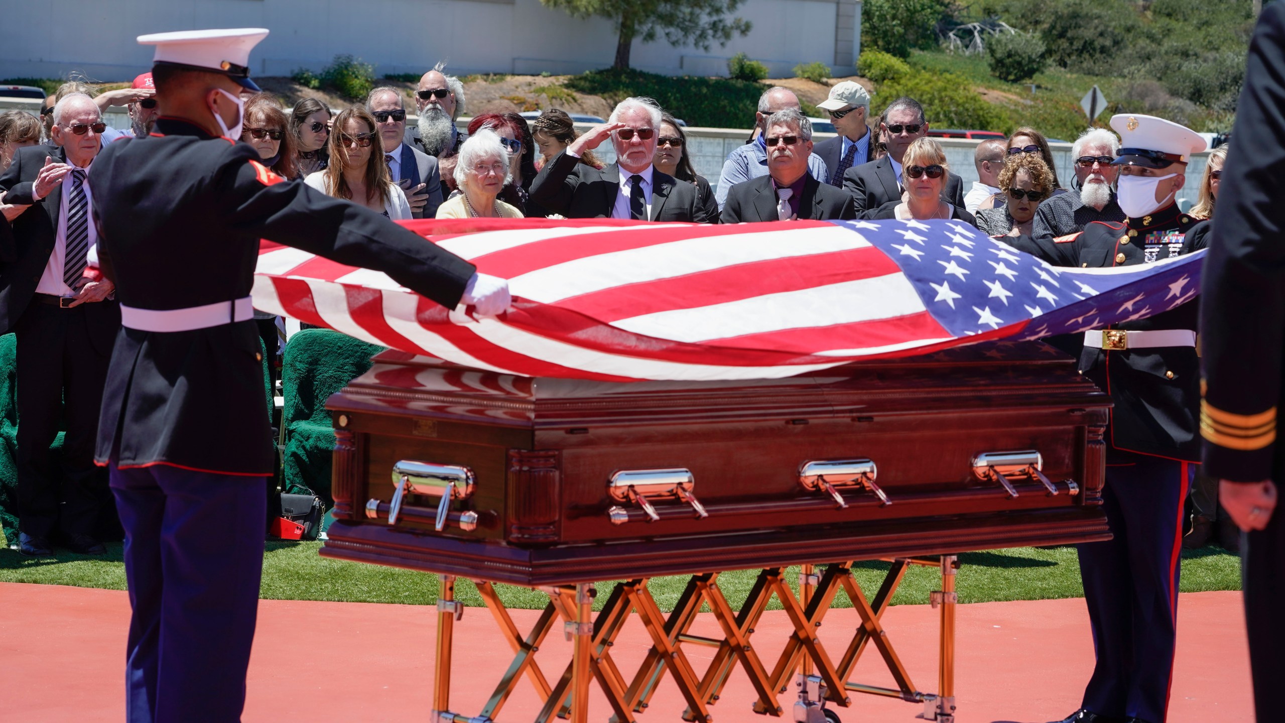 A military honor guard drapes a U.S. flag over the casket of Marine Corps, Pfc. John Franklin Middleswart for a full military honors at Fort Rosecrans National Cemetery, Tuesday, June 8, 2021 in San Diego. Eighty years after he died in the attack on Pearl Harbor and just months after his remains were finally identified, the California Marine has been laid to rest with full military honors. About 50 people attended the ceremony Tuesday for Middleswart in his hometown of San Diego, the Union-Tribune reported. (Nelvin C. Cepeda/The San Diego Union-Tribune via AP)