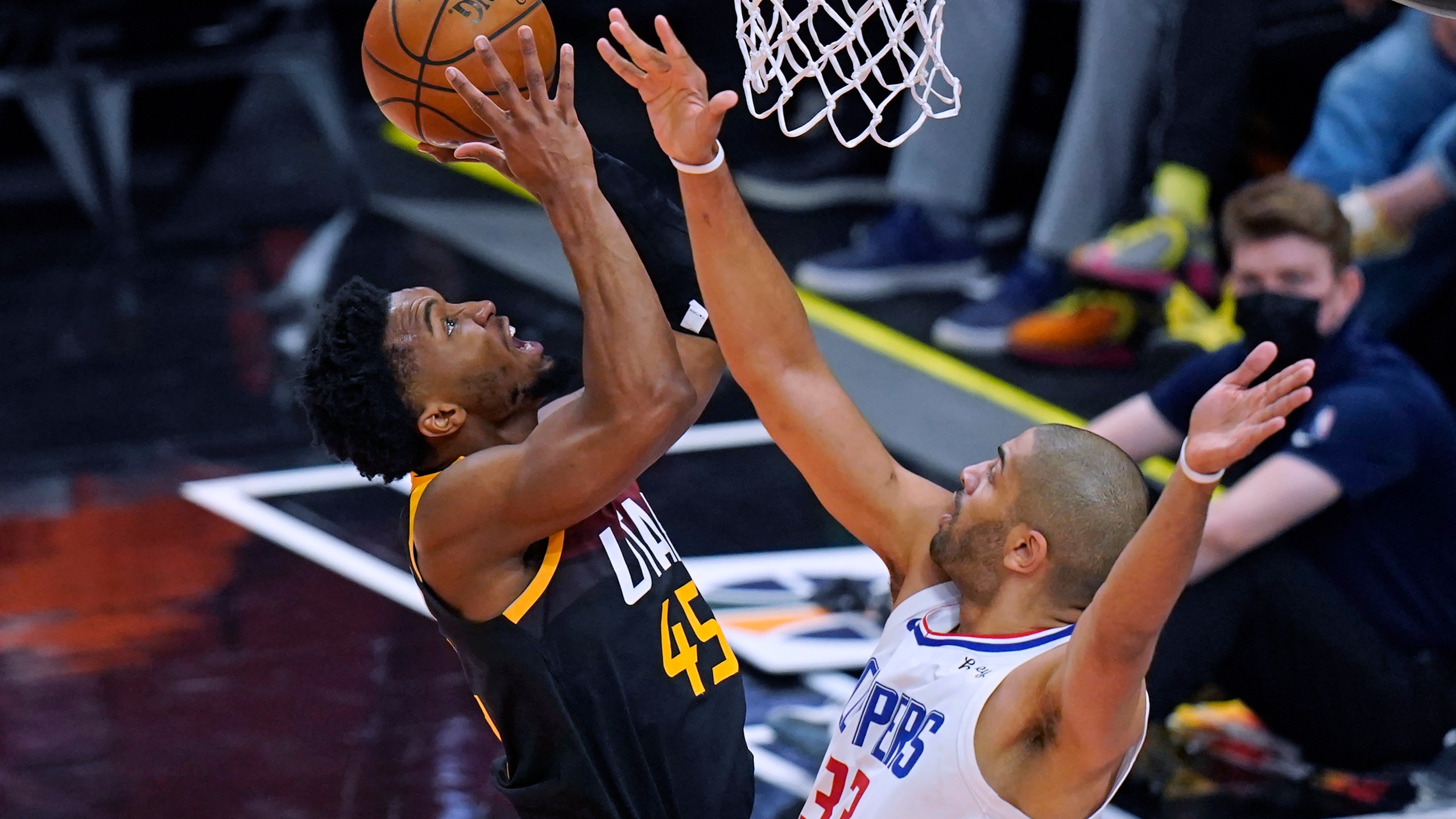 Los Angeles Clippers forward Nicolas Batum (33) defends as Utah Jazz guard Donovan Mitchell, left, goes to the basket during the first half of Game 2 of a second-round NBA basketball playoff series on June 10, 2021, in Salt Lake City. (Rick Bowmer / Associated Press)