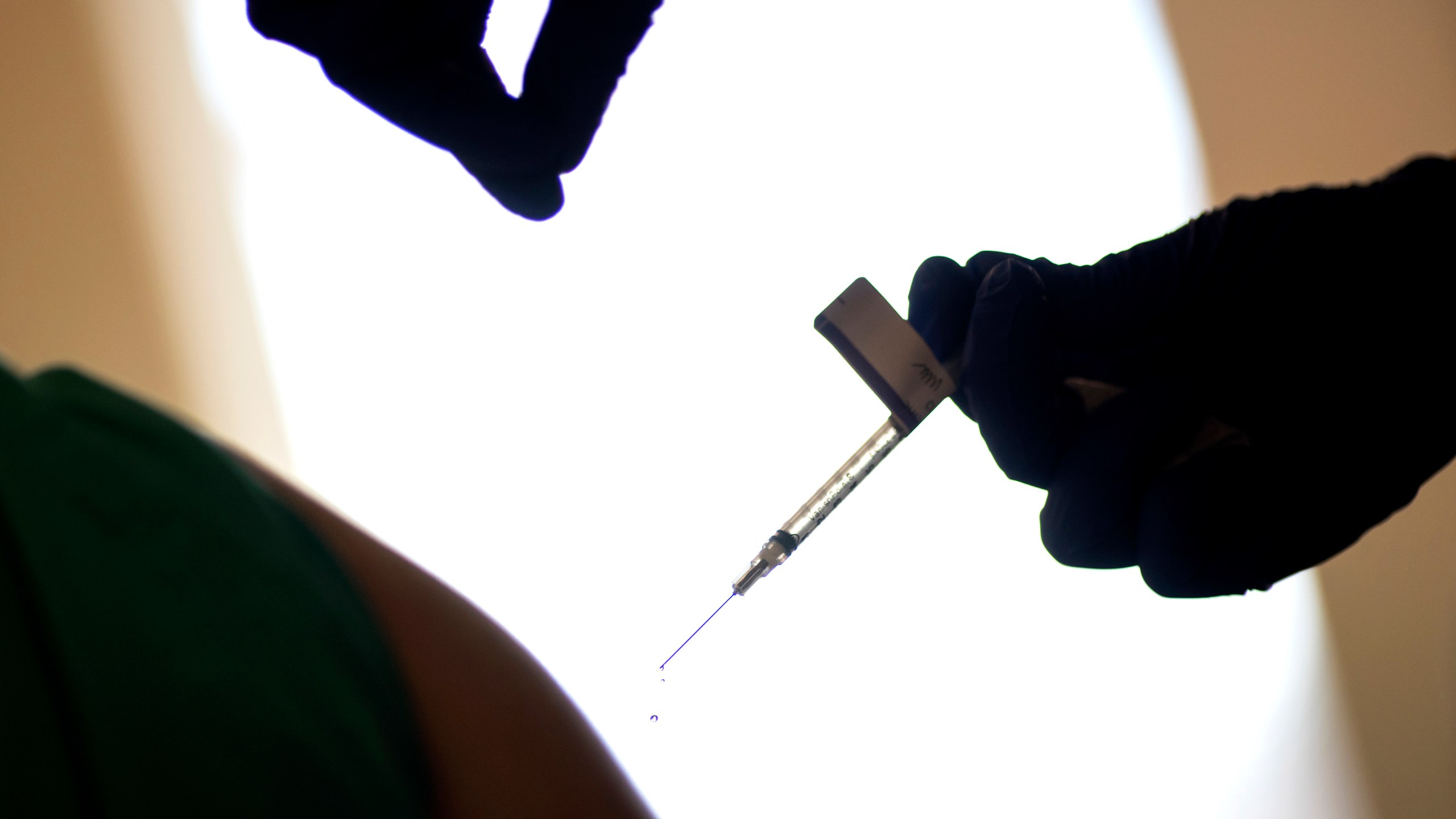 In this Tuesday, Dec. 15, 2020 file photo, a droplet falls from a syringe after a health care worker was injected with the Pfizer-BioNTech COVID-19 vaccine at a hospital in Providence, R.I. (AP Photo/David Goldman, File)