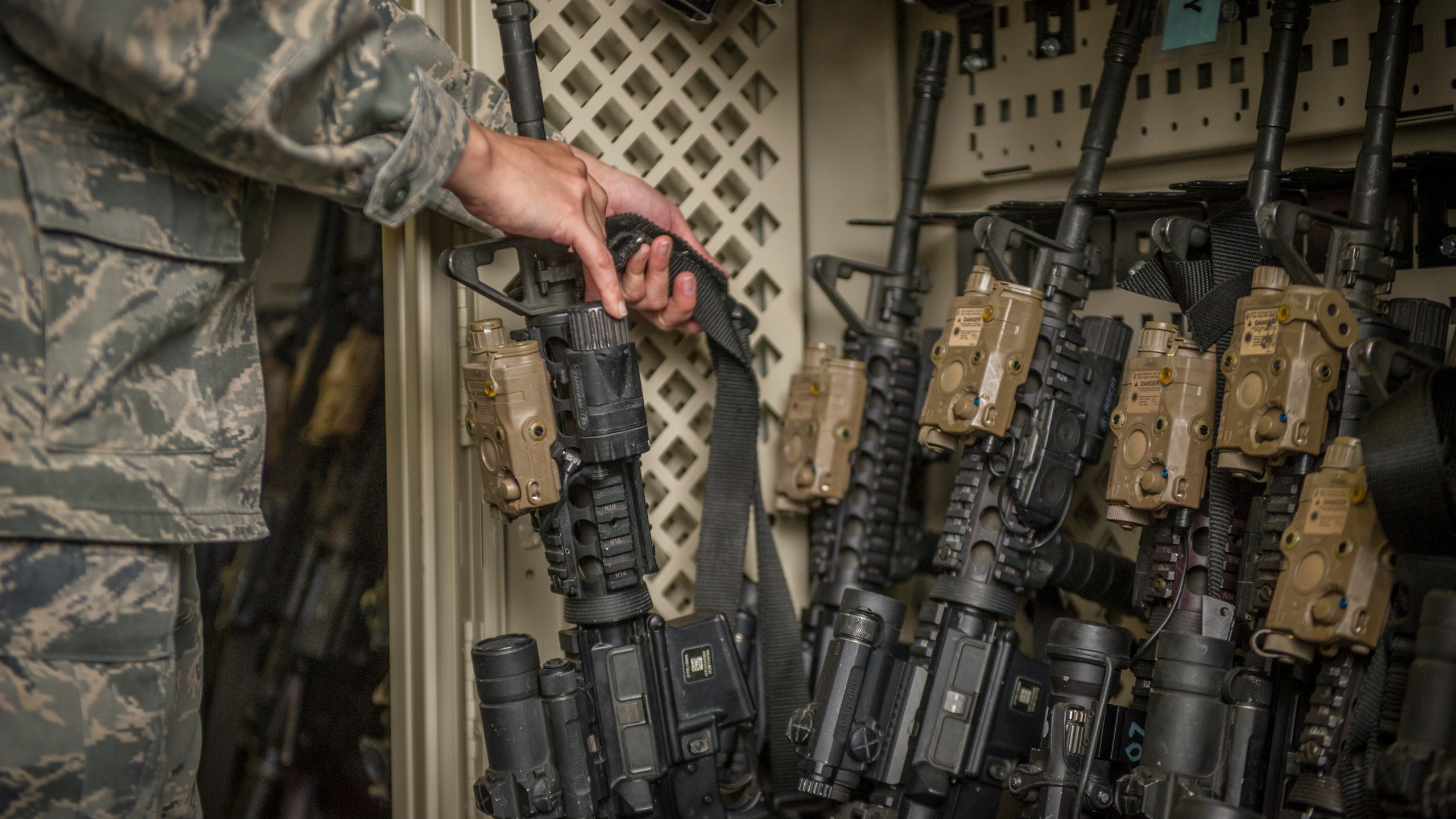 In this April 2, 2015, photo made available by the U.S. Air Force, a senior airman from the 49th Security Forces Squadron in charge of the armory, returns an M4 carbine to a rack at Holloman Air Force Base, N.M. (Airman 1st Class Aaron Montoya/U.S. Air Force via AP)