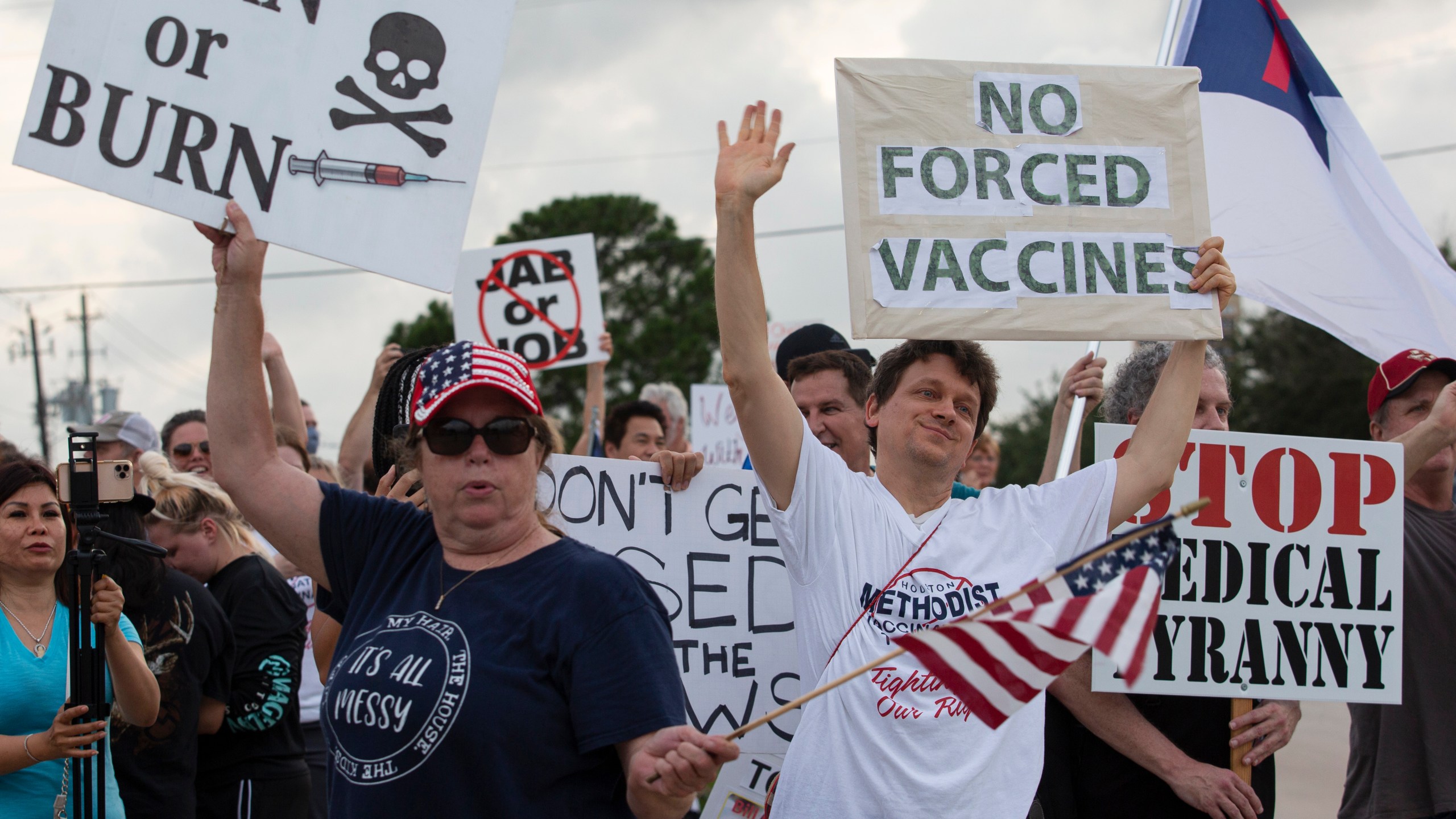 In this June 7, 2021, file photo, demonstrators at Houston Methodist Baytown Hospital in Baytown, Texas, wave at cars that honk at them to support their protest against a policy that says hospital employees must get vaccinated against COVID-19 or lose their jobs. (Yi-Chin Lee/Houston Chronicle via AP)