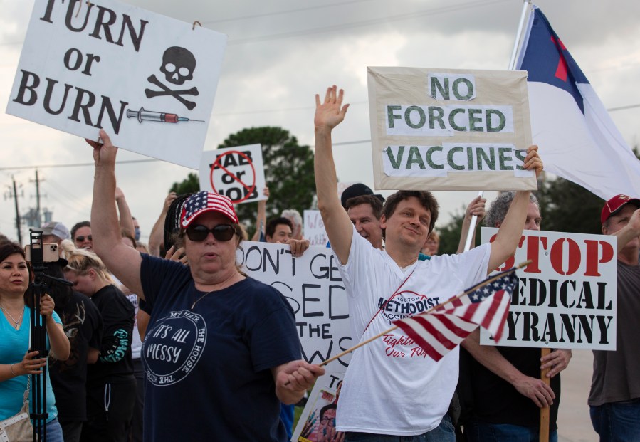 In this June 7, 2021, file photo, demonstrators at Houston Methodist Baytown Hospital in Baytown, Texas, wave at cars that honk at them to support their protest against a policy that says hospital employees must get vaccinated against COVID-19 or lose their jobs. (Yi-Chin Lee/Houston Chronicle via AP)