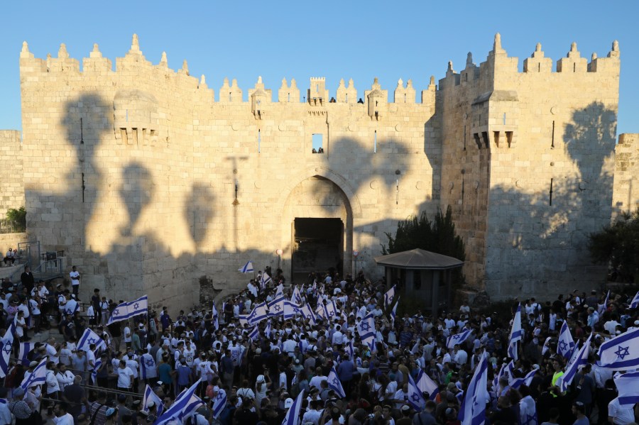 Jewish ultranationalists wave Israeli flags during the "Flags March," next to Damascus gate, outside Jerusalem's Old City on June 15, 2021. (AP Photo/Mahmoud Illean)