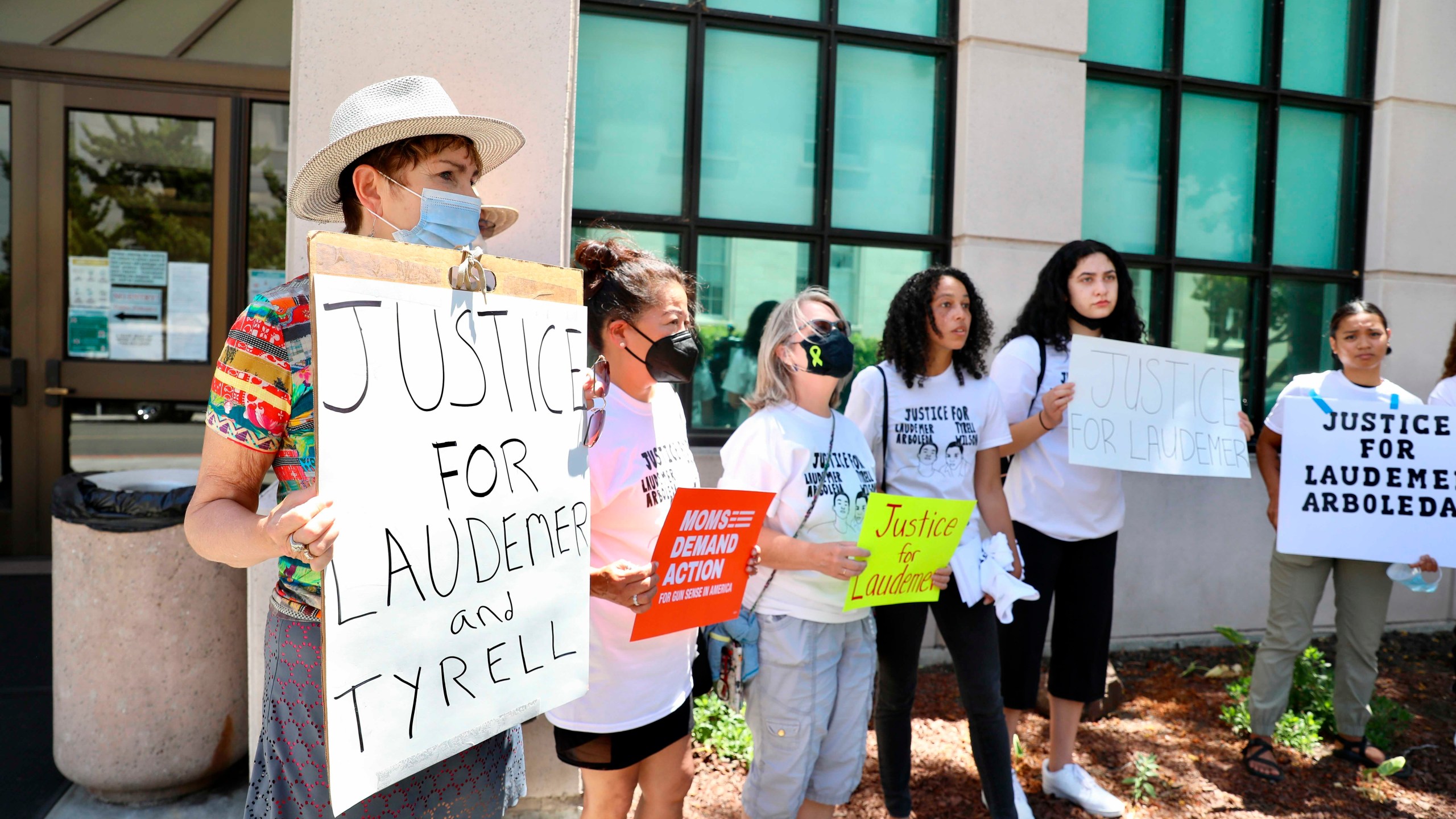 Supporters of the late Laudemer Arboleda and the late Tyrell Wilson hold signs following an arraignment hearing for Danville police officer Andrew Hall outside the A.F. Bray Courthouse in Martinez, Calif., on June 16, 2021.(Yalonda M. James/San Francisco Chronicle via AP)