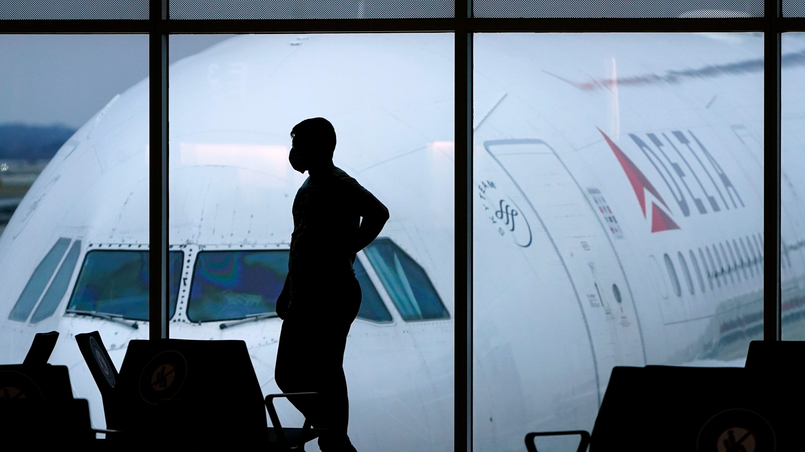 In this Feb. 18, 2021 file photo, a passenger wears a face mask to help prevent the spread of the new coronavirus as he waits for a Delta Airlines flight at Hartsfield-Jackson International Airport in Atlanta. (AP Photo/Charlie Riedel)