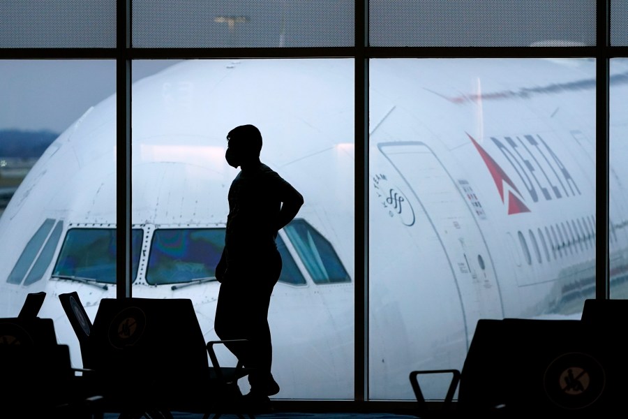 In this Feb. 18, 2021 file photo, a passenger wears a face mask to help prevent the spread of the new coronavirus as he waits for a Delta Airlines flight at Hartsfield-Jackson International Airport in Atlanta. (AP Photo/Charlie Riedel)