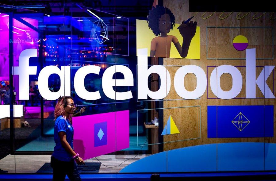 In this April 18, 2017, file photo, a conference worker passes a demo booth at Facebook's annual F8 developer conference, in San Jose, Calif. (AP Photo/Noah Berger, File)