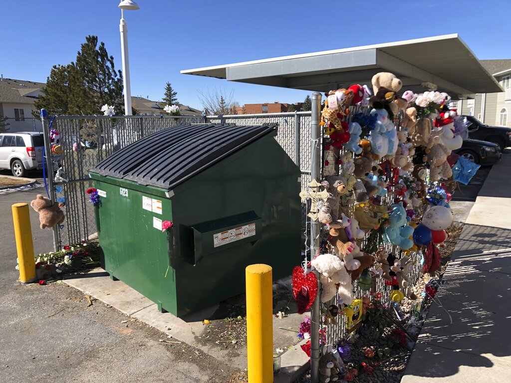 In this Feb. 22, 2021, file photo, stuffed animals and notes of condolences are seen attached to a fence around a dumpster at a Cheyenne, Wyo., apartment complex where a 2-year-old boy was found dead. (AP Photo/Mead Gruver,File)