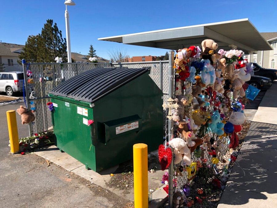 In this Feb. 22, 2021, file photo, stuffed animals and notes of condolences are seen attached to a fence around a dumpster at a Cheyenne, Wyo., apartment complex where a 2-year-old boy was found dead. (AP Photo/Mead Gruver,File)