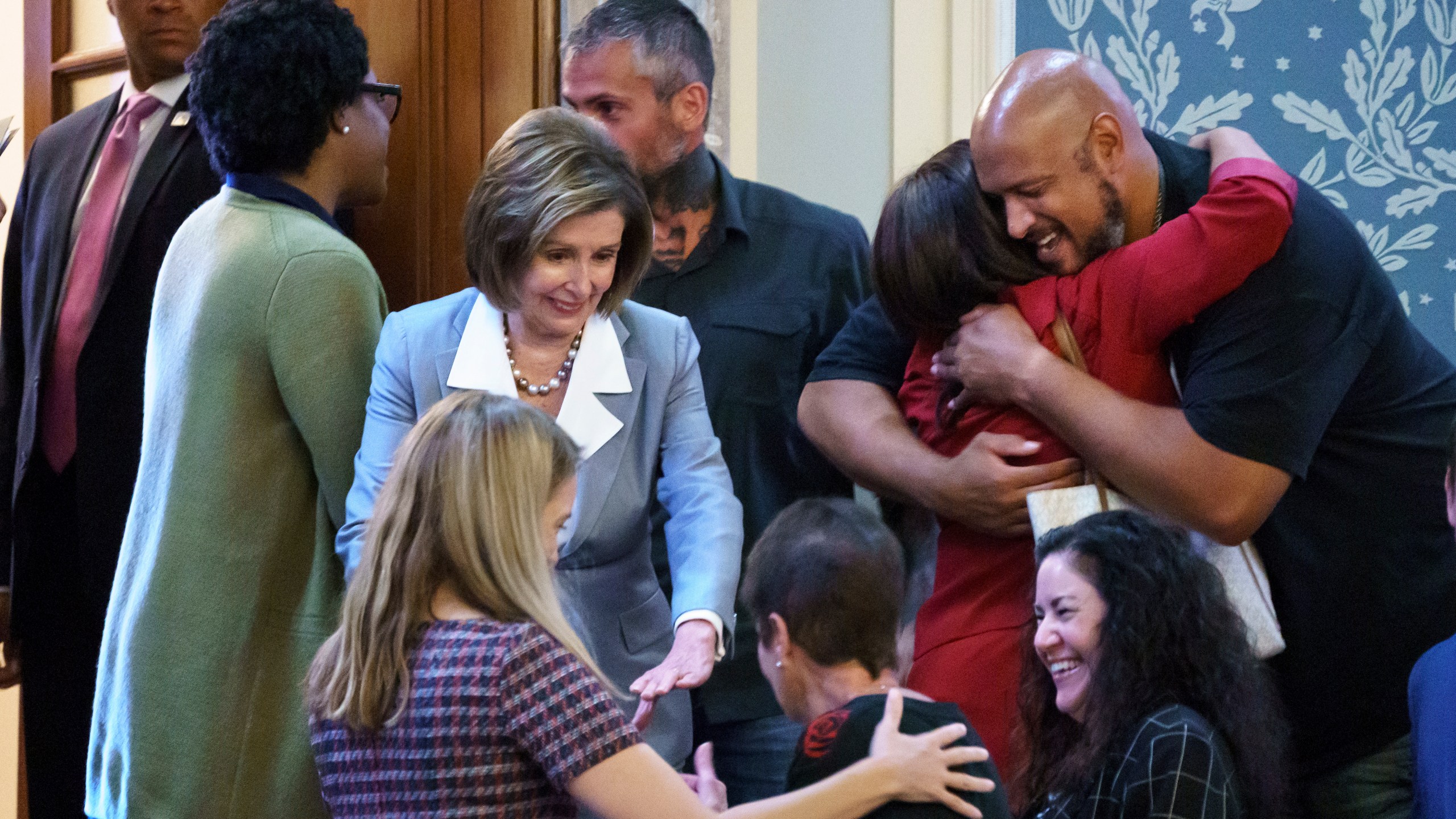 Speaker of the House Nancy Pelosi, D-Calif., center, greets police officers and their family members in the House chamber during the vote to create a select committee to investigate the Jan. 6 Capitol insurrection, at the Capitol in Washington, Wednesday, June 30, 2021. Pelosi reaches out to Gladys Sicknick, bottom center, the mother of Brian Sicknick, a Capitol Police officer who died from injuries sustained during attack. At lower right is Sandra Garza, Brian Sicknick's partner. At upper right, Capitol Police Officer Harry Dunn, who faced the rioters, smiles as he is hugged by Rep. Norma Torres, D-Calif. Metropolitan Police Officer Michael Fanone stands behind Pelosi. (AP Photo/J. Scott Applewhite)